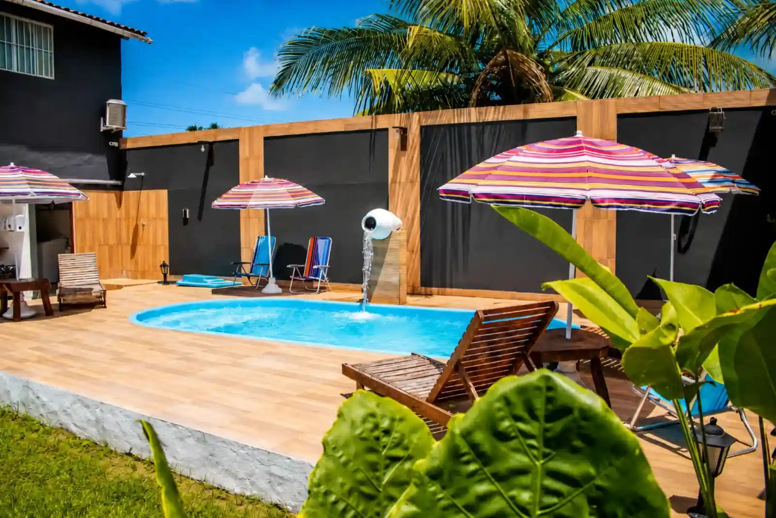 The outdoor pool and wooden deck under a clear sky