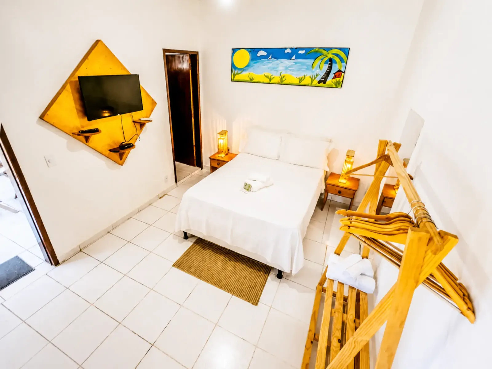 Double room with one full bed, wall-mounted television and bedside lamps
