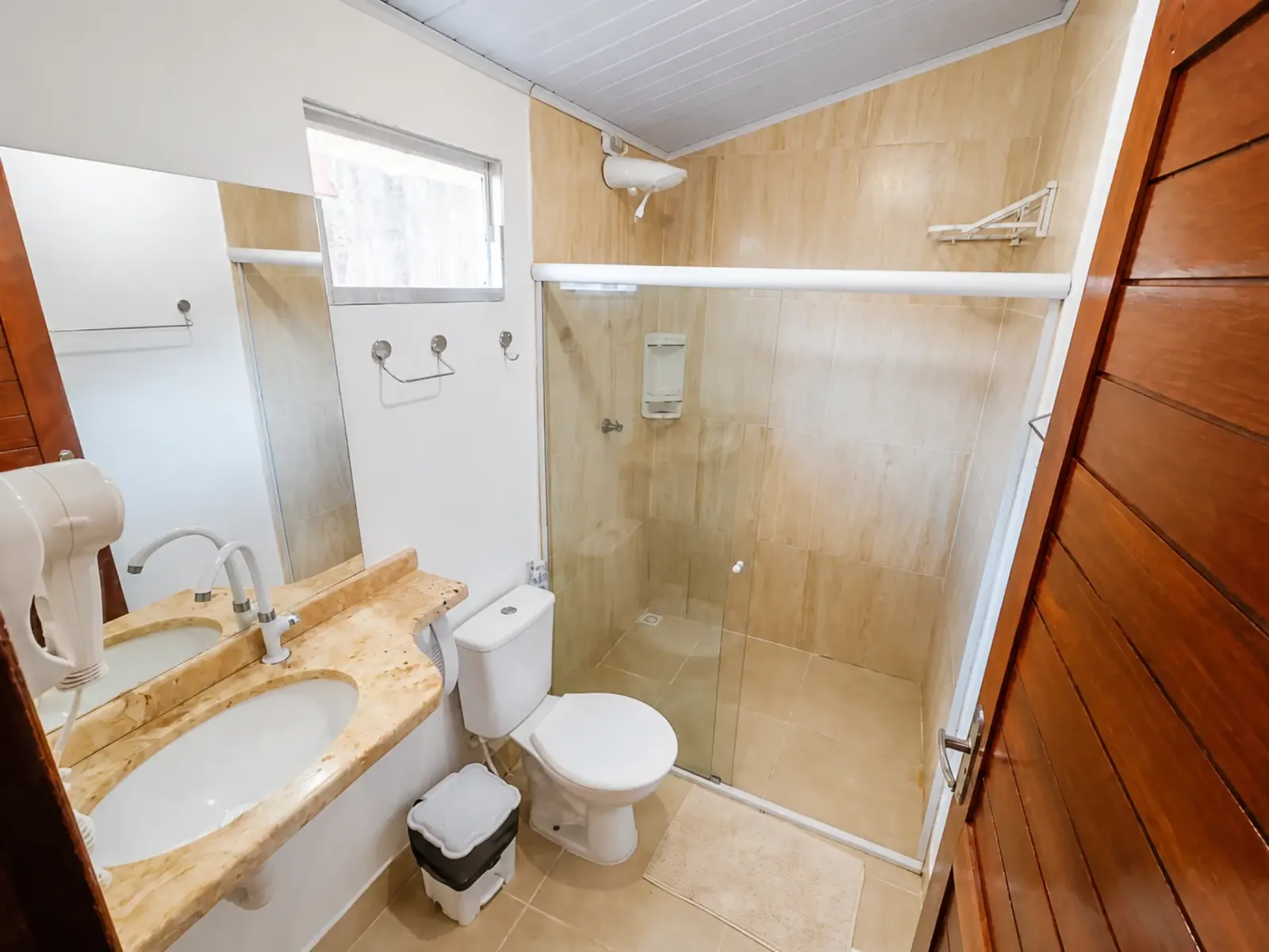 Private bathroom with a glass shower enclosure, stone washbasin and hairdryer